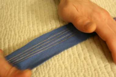 strip of fabric with conductive thread lines being stretched